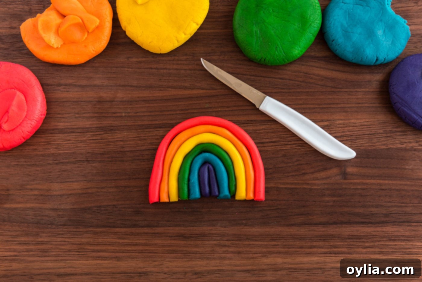 Shaped rainbow cookie dough with a lollipop stick inserted, ready for baking.