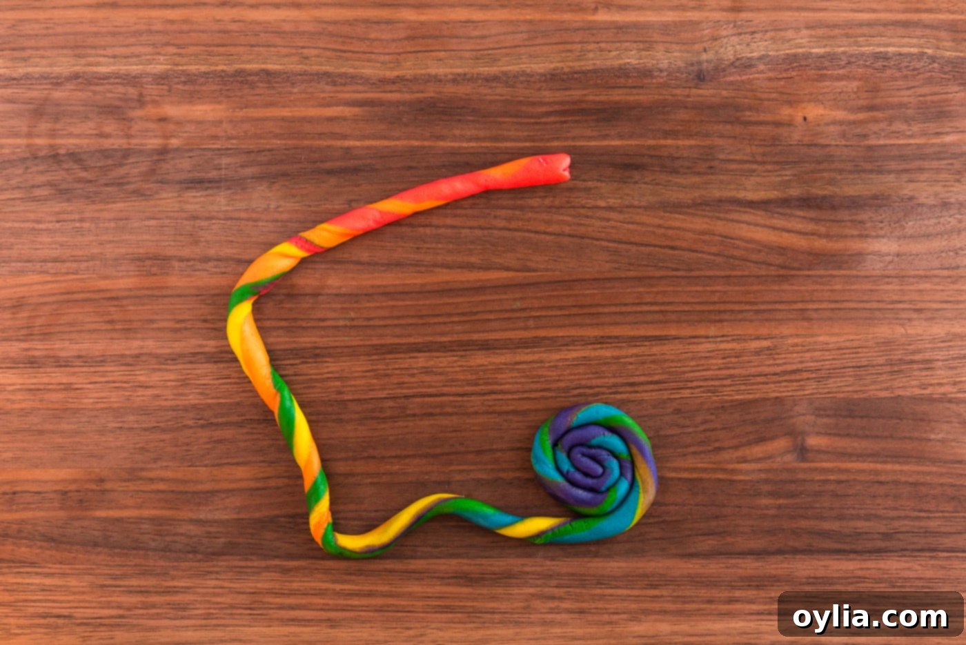 Coiled snake cookie dough showcasing a blend of rainbow colors.