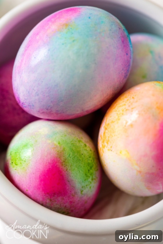 Vibrantly colored tie-dye Easter eggs with swirling patterns on a white background, showcasing unique designs