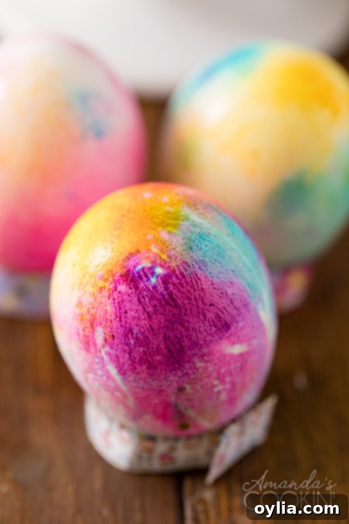 A finished tie-dye Easter egg displaying an exquisite blend of blues, greens, and purples in a swirling pattern