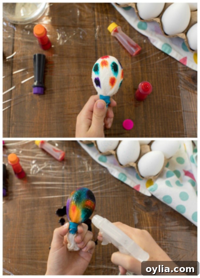 Colorful drops of liquid food coloring being applied to an egg wrapped in cheesecloth, showing the beginning of the tie-dye pattern
