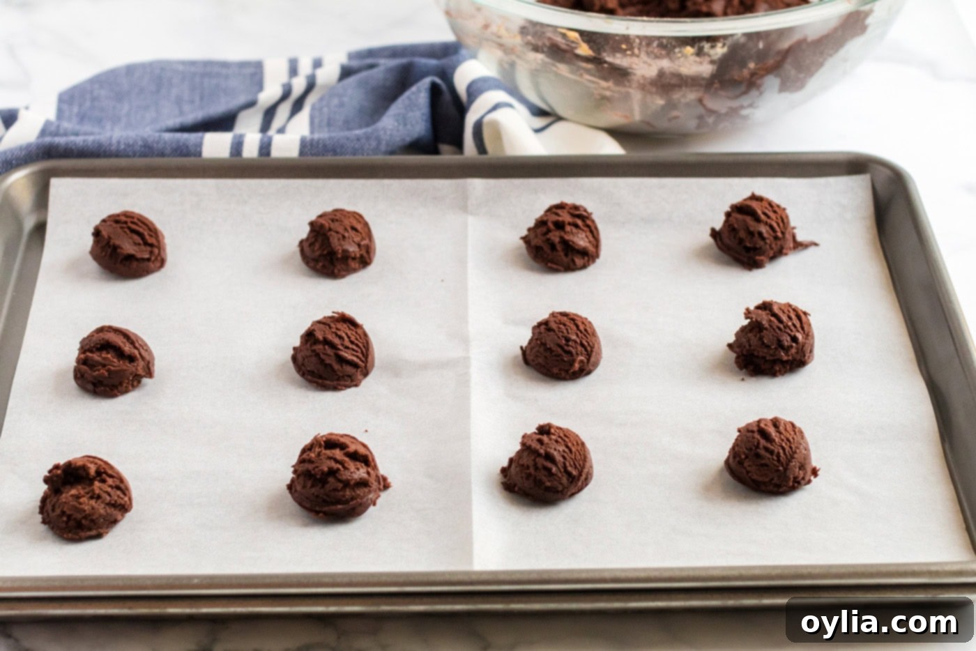 Chocolate Peanut Butter Cookie dough balls on a parchment lined baking sheet