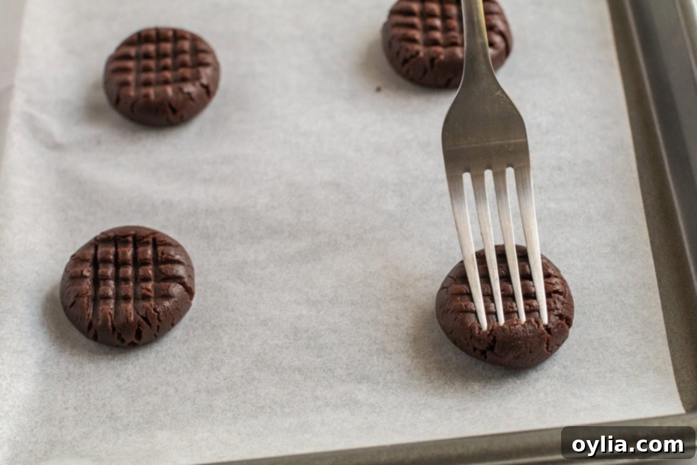 Fork flattening a Chocolate Peanut Butter Cookie dough ball