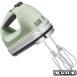 A close-up of a sleek, modern hand mixer in a kitchen setting, ready for use.