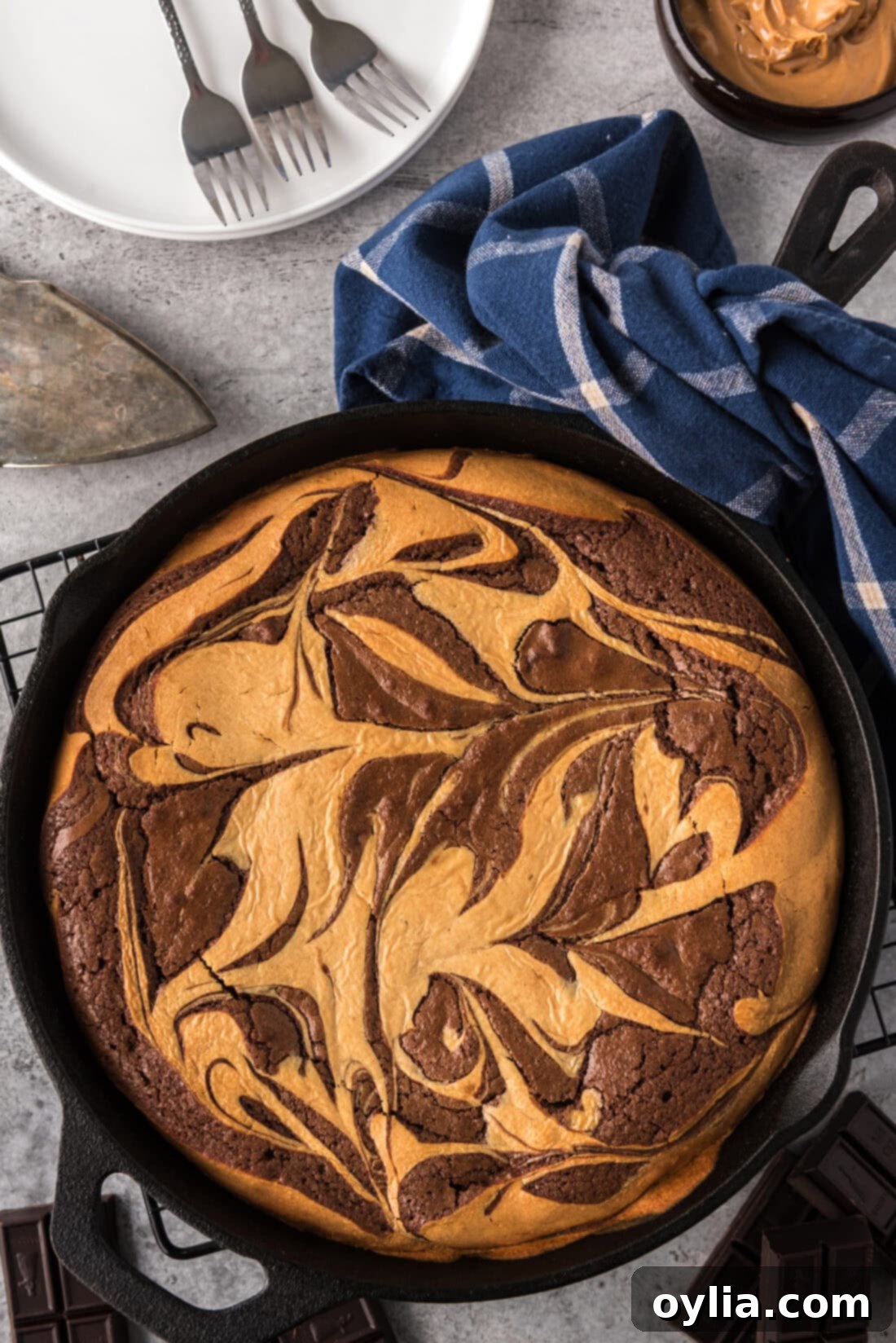 Peanut Butter Marbled Brownie Skillet Pie with plates in the background