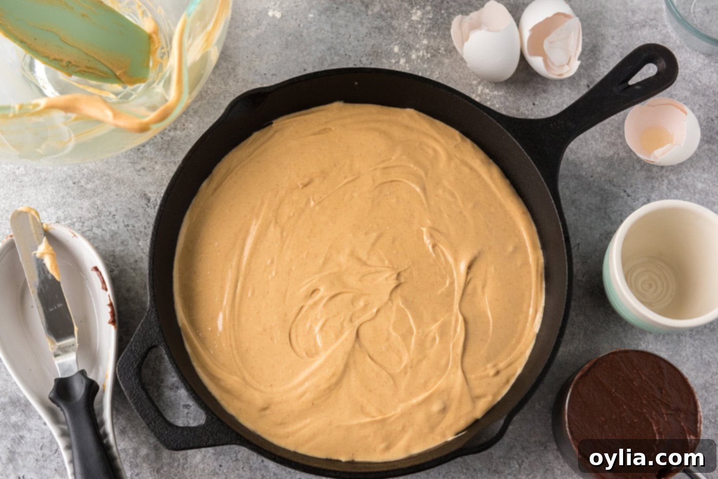 peanut butter cream cheese mixture added on top of brownie batter in a skillet