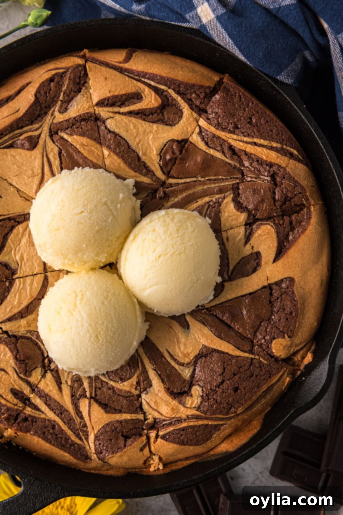 Close up photo of a Peanut Butter Marbled Brownie Skillet Pie topped with three scoops of ice cream