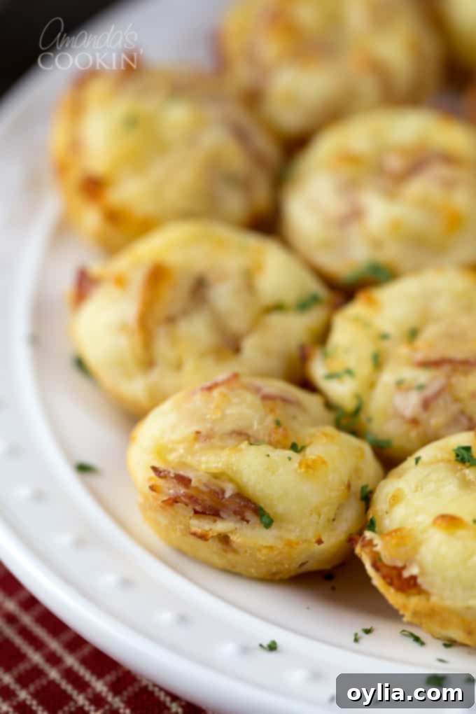 A close up of pizza puffs resting on a white plate.
