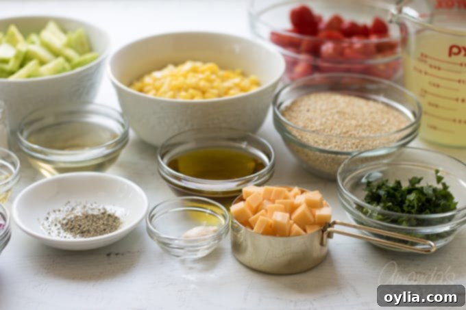 A flat lay of all the fresh, colorful ingredients ready to be chopped for the summer vegetable quinoa salad.
