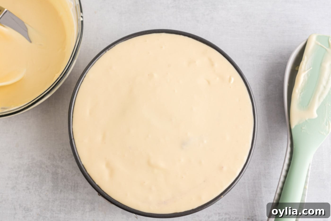 A springform pan completely filled with cheesecake batter, ready for baking, showing a smooth top layer.