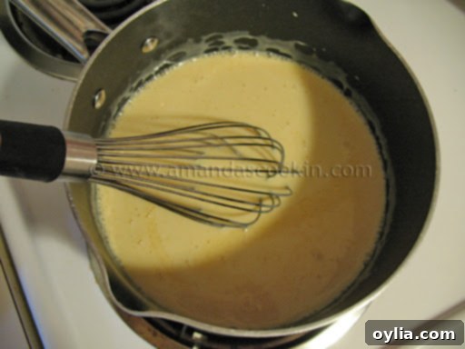 Overhead view of sweetened condensed milk and freshly squeezed Sunkist orange juice simmering in a saucepan