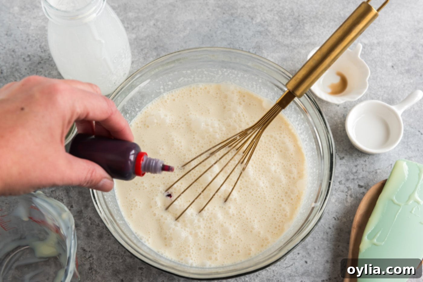 Adding red food coloring to the peppermint ice cream base to achieve the signature pink hue.