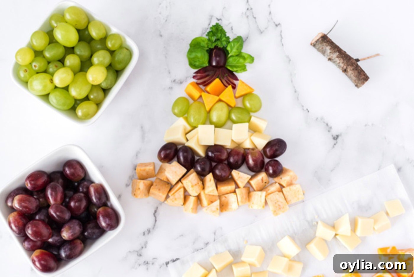 Step-by-step process of building a Christmas Tree Cheese Platter with alternating layers of cheese and grapes