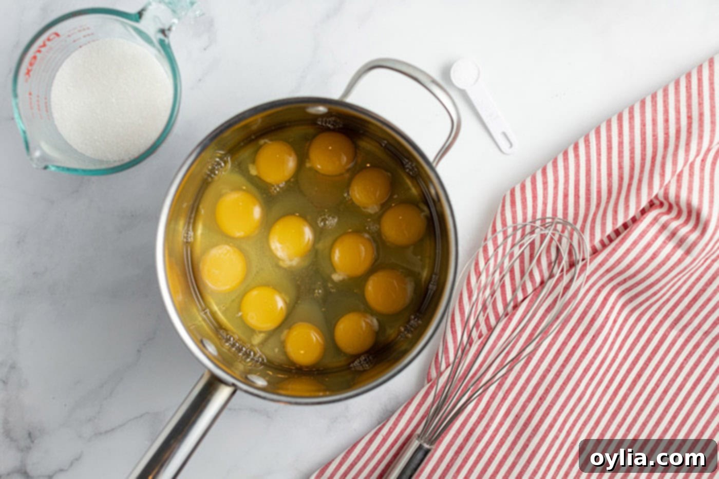 Saucepan of eggs with sugar and salt next to it