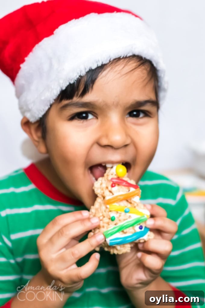little boy happily eating a Christmas Tree Rice Krispie Treat