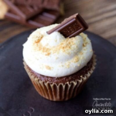 A close up of a s'mores cupcake topped with a Hershey bar piece.