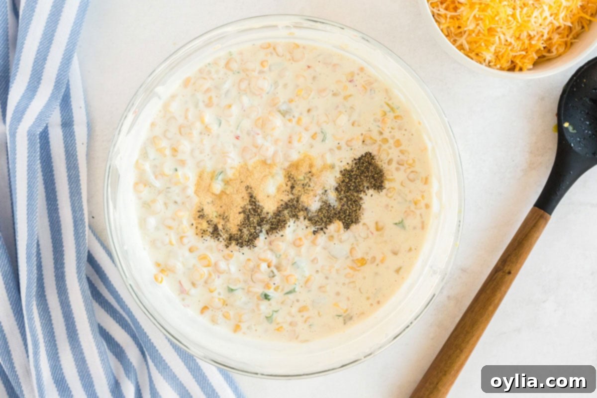 bowl of corn dip with seasonings added to the top of it
