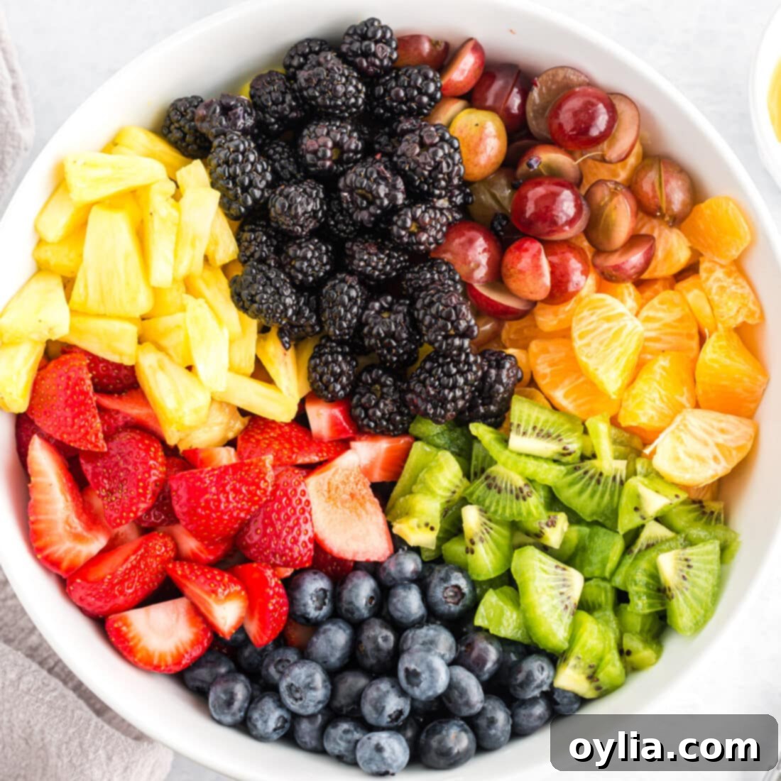 Assortment of vibrant fresh fruits beautifully arranged in a large bowl, ready to be dressed