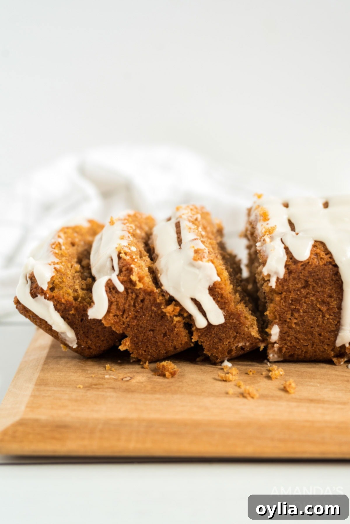 Slices of iced cantaloupe quick bread, showing its moist texture and vibrant color.
