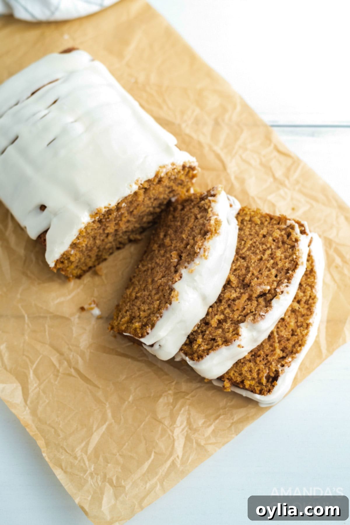 Several slices of cantaloupe quick bread arranged on parchment paper, showing the interior texture and glaze.