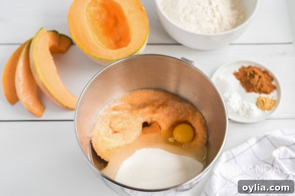 Wet ingredients for cantaloupe quick bread, including eggs, oil, sugar, vanilla, and cantaloupe puree, mixed in a large bowl.