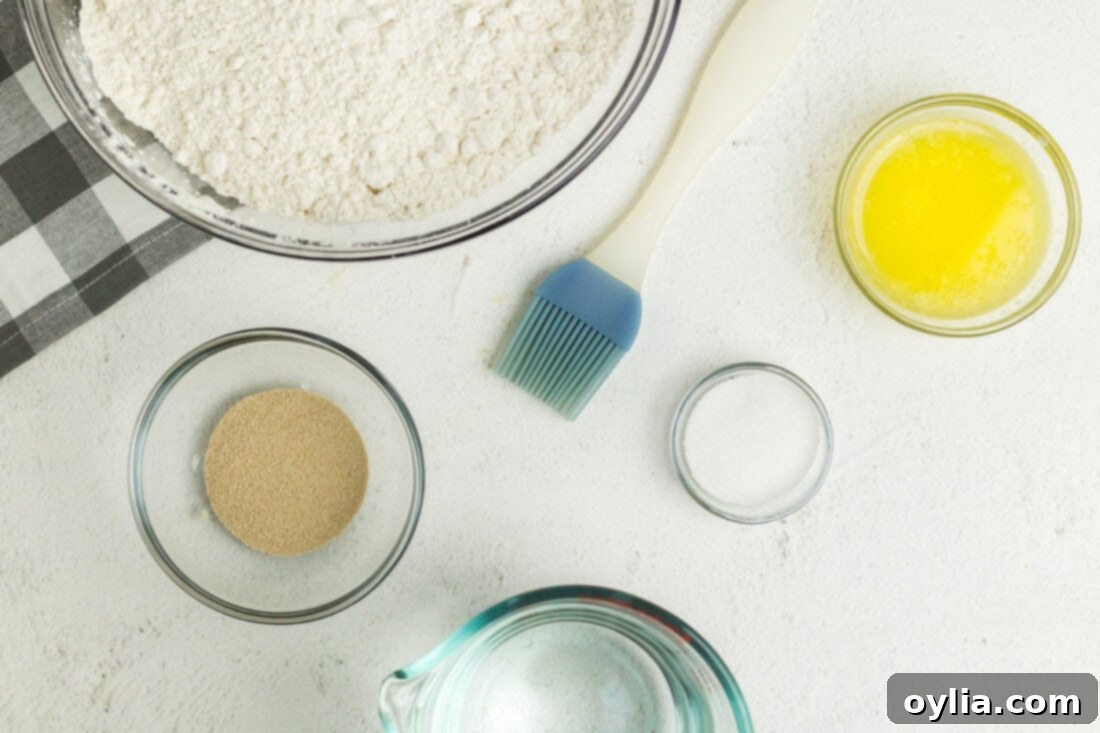 A collection of simple ingredients laid out for making Air Fryer Pretzel Bites, including flour, yeast, sugar, salt, and butter.