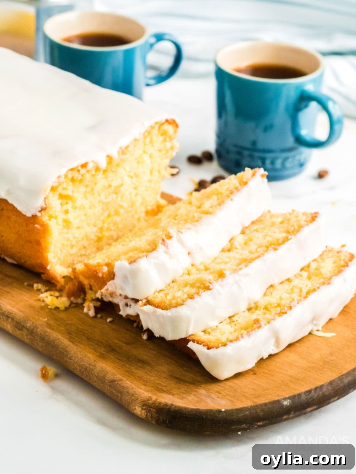 sliced lemon loaf cake, showing the moist interior and glistening glaze