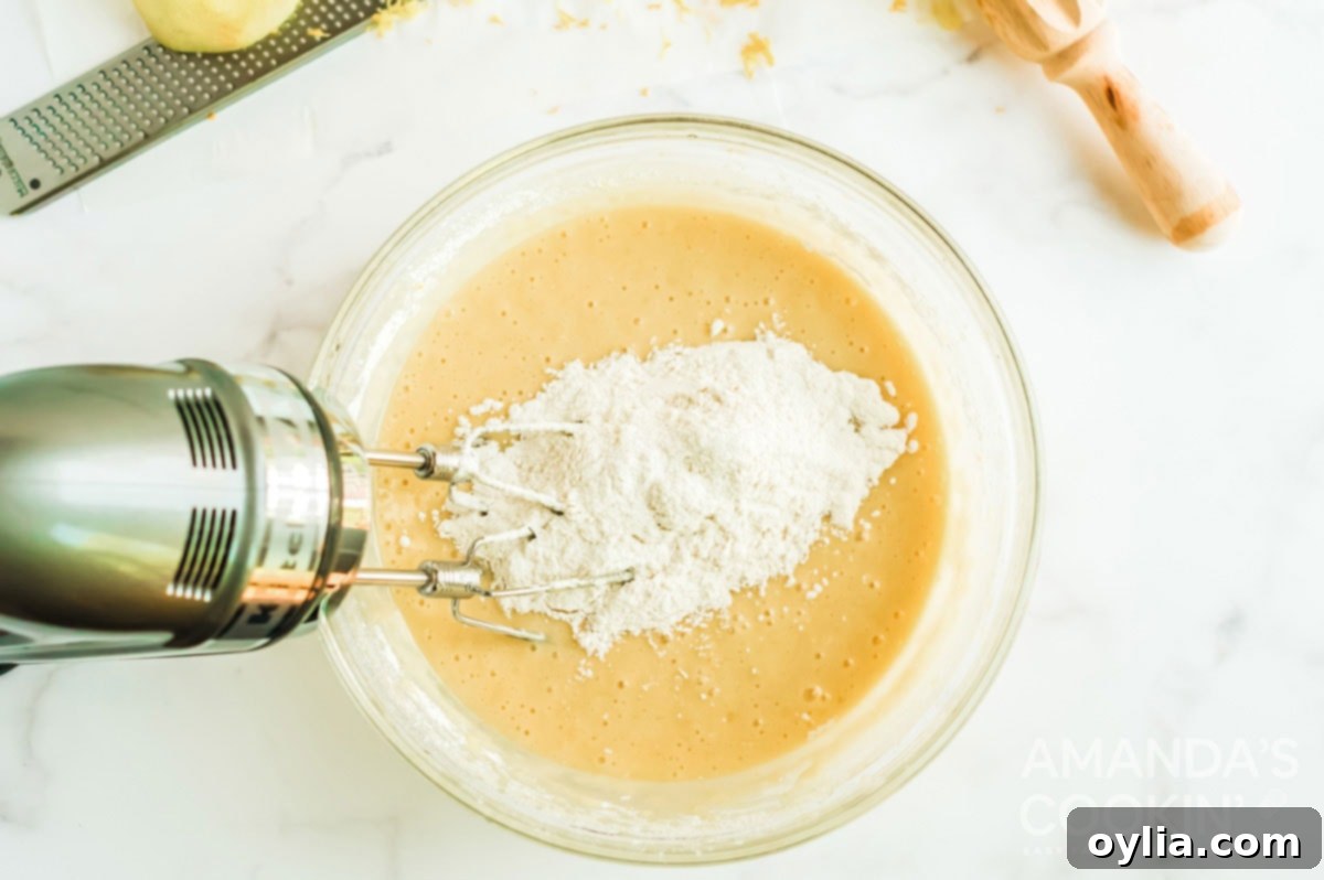 flour mixture in batter in bowl, showing dry ingredients being added to wet