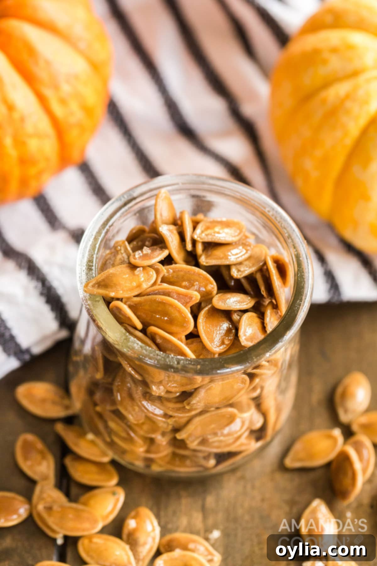 There's something nostalgic about a pan full of salty roasted pumpkin seeds! It's a fall and Halloween tradition after carving pumpkins. jar of perfectly roasted pumpkin seeds, a delicious and healthy snack for fall.