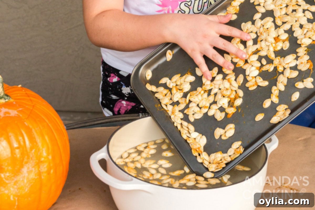 Golden Roasted Pepitas 3 child carefully adding pumpkin seeds to a pot of water for cleaning.