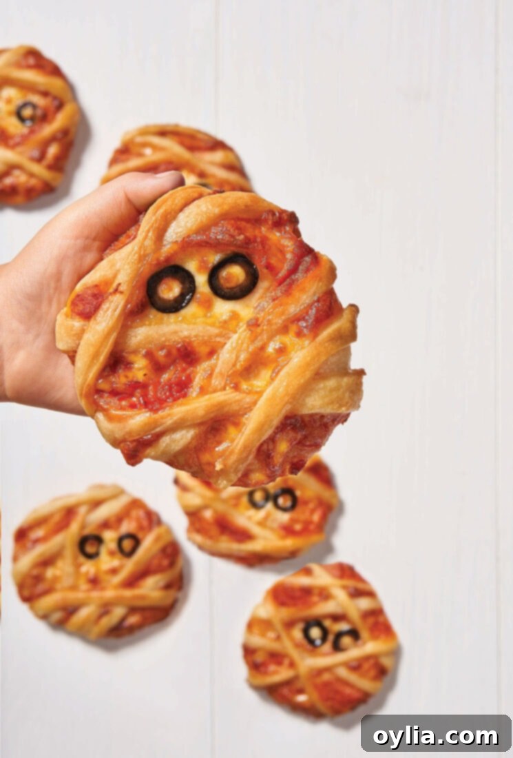 Spooky-Fun Halloween Bites 3 child holding mini mummy pizza