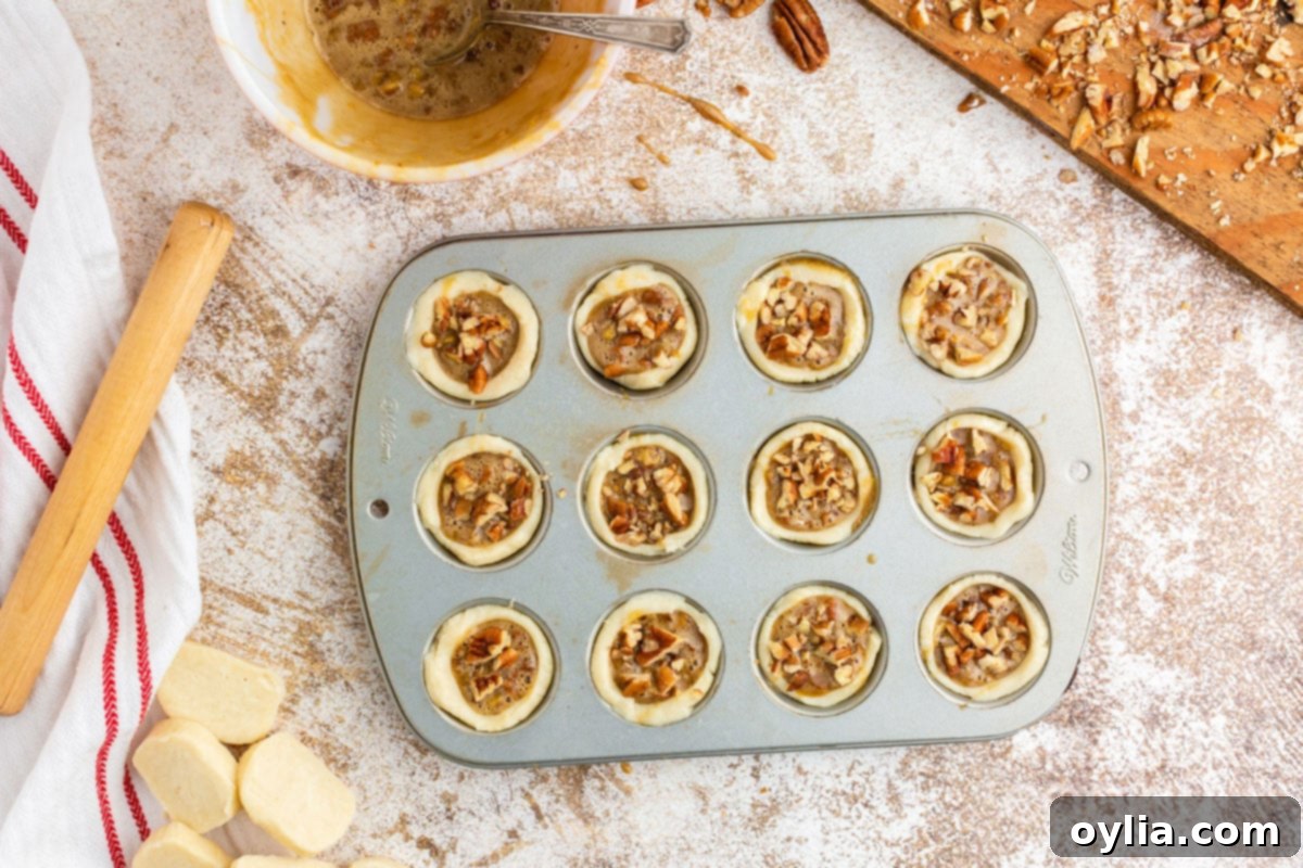 unbaked pecan tassies in a muffin tin