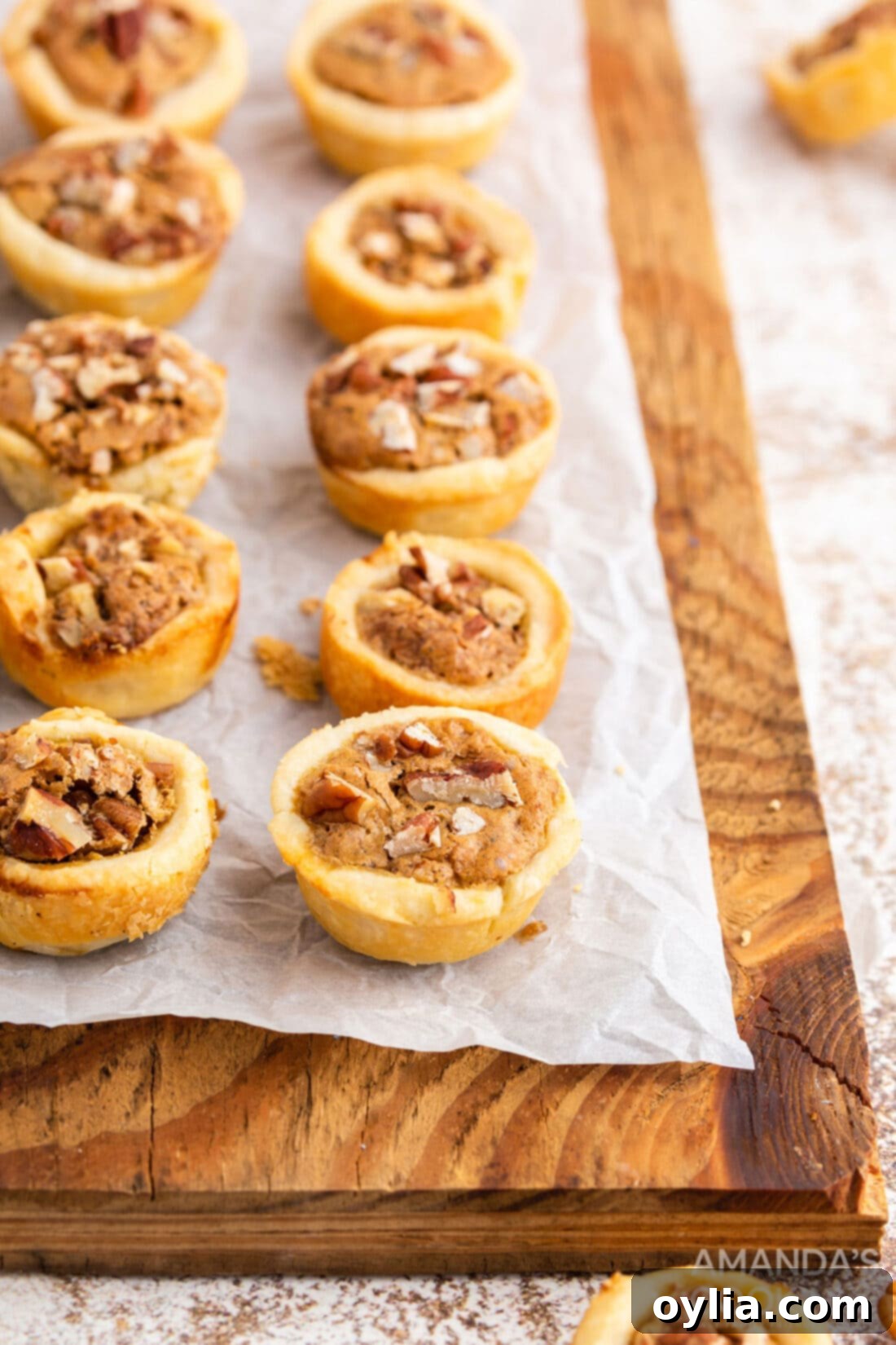 Mini Pecan Pie Perfection 3 pecan tassies on a wood cutting board