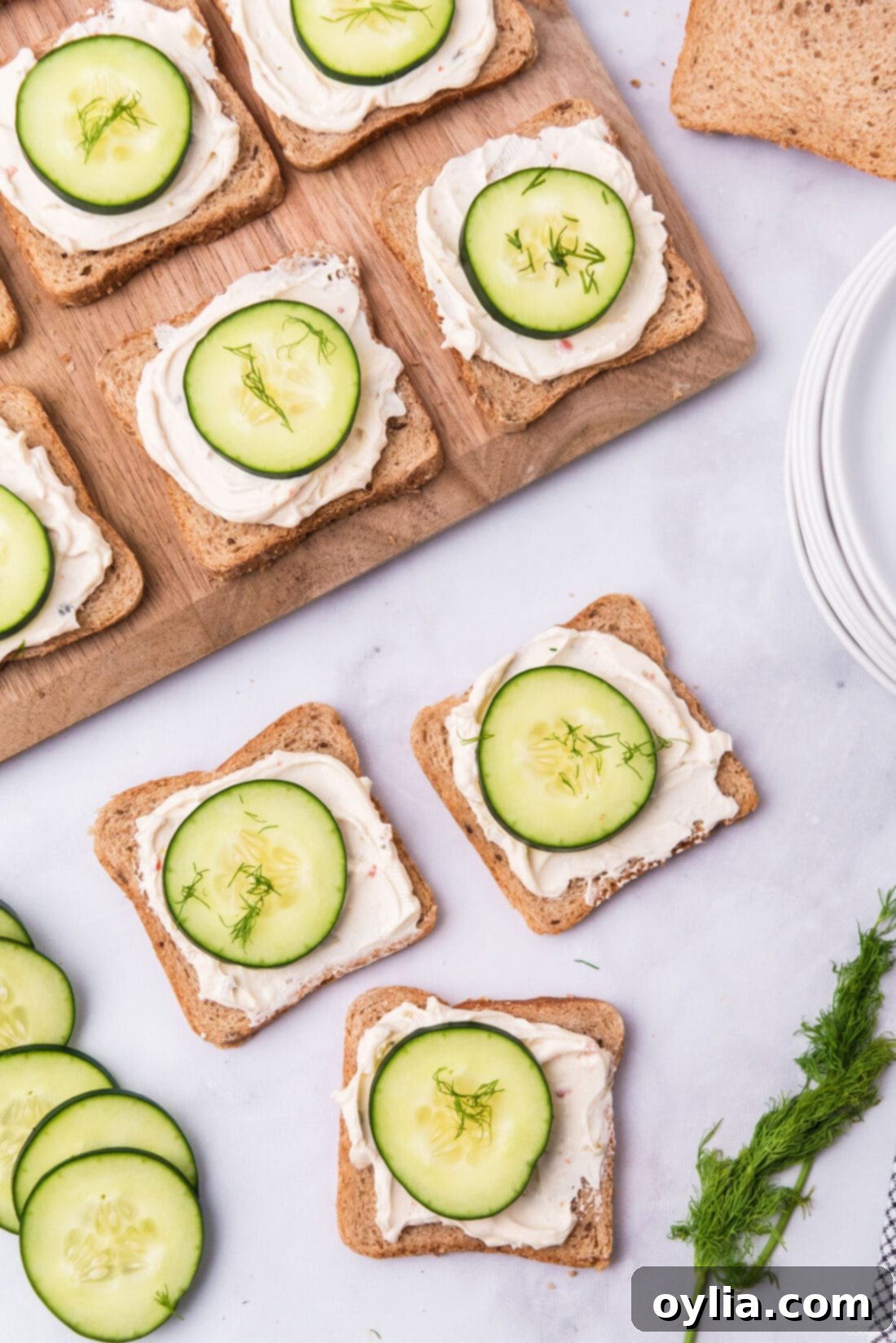 MINI CUCUMBER SANDWICHES ON A WOOD BOARD