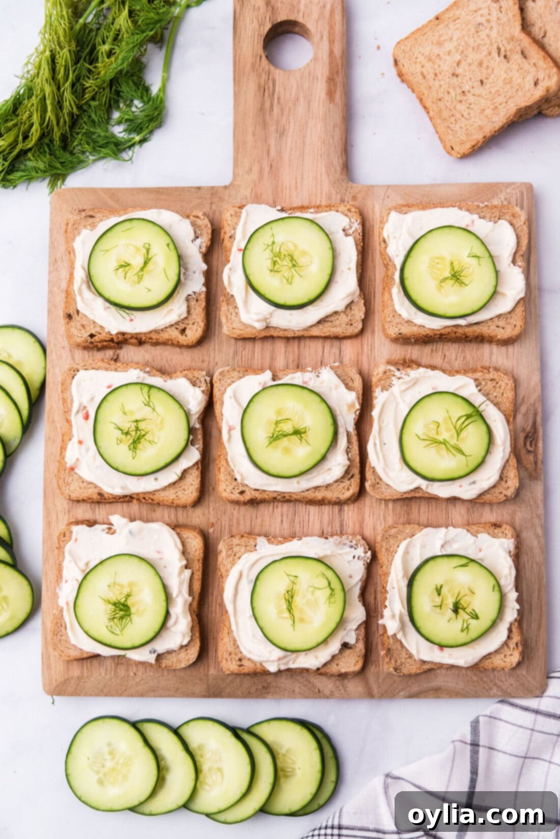 wood board with open faced cucumber sandwiches
