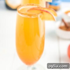 A elegant champagne flute with a caramel apple mimosa, suggesting a celebratory drink.