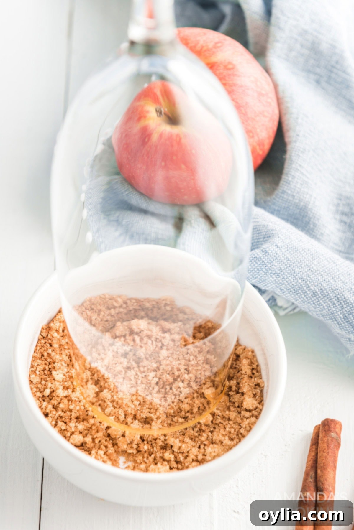 Dipping the caramel-coated rim of a champagne glass into a mixture of brown sugar and cinnamon.