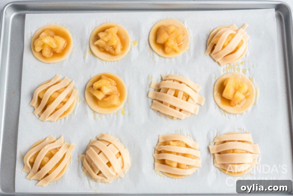Dough strips arranged in a simple lattice pattern over the apple and caramel filling of mini apple pie cookies.