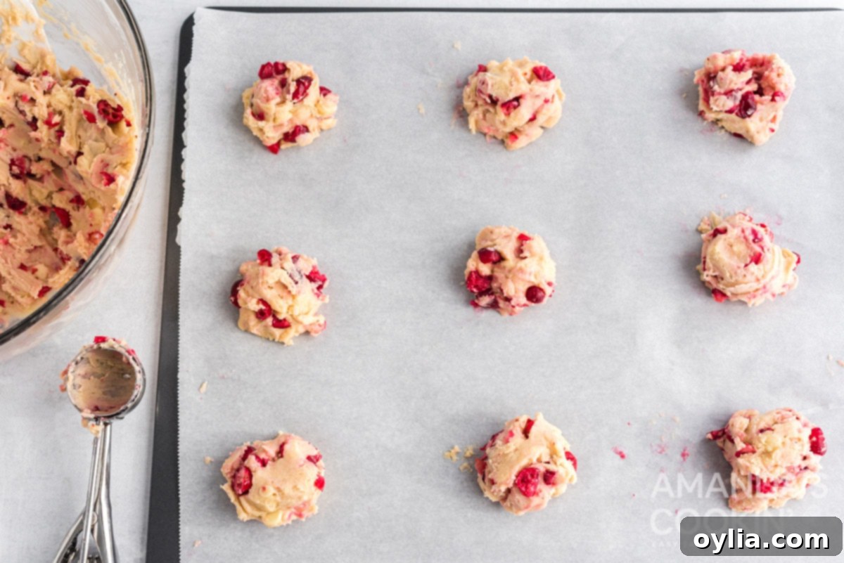 White Chocolate Cranberry Cookie dough balls spaced on a baking sheet