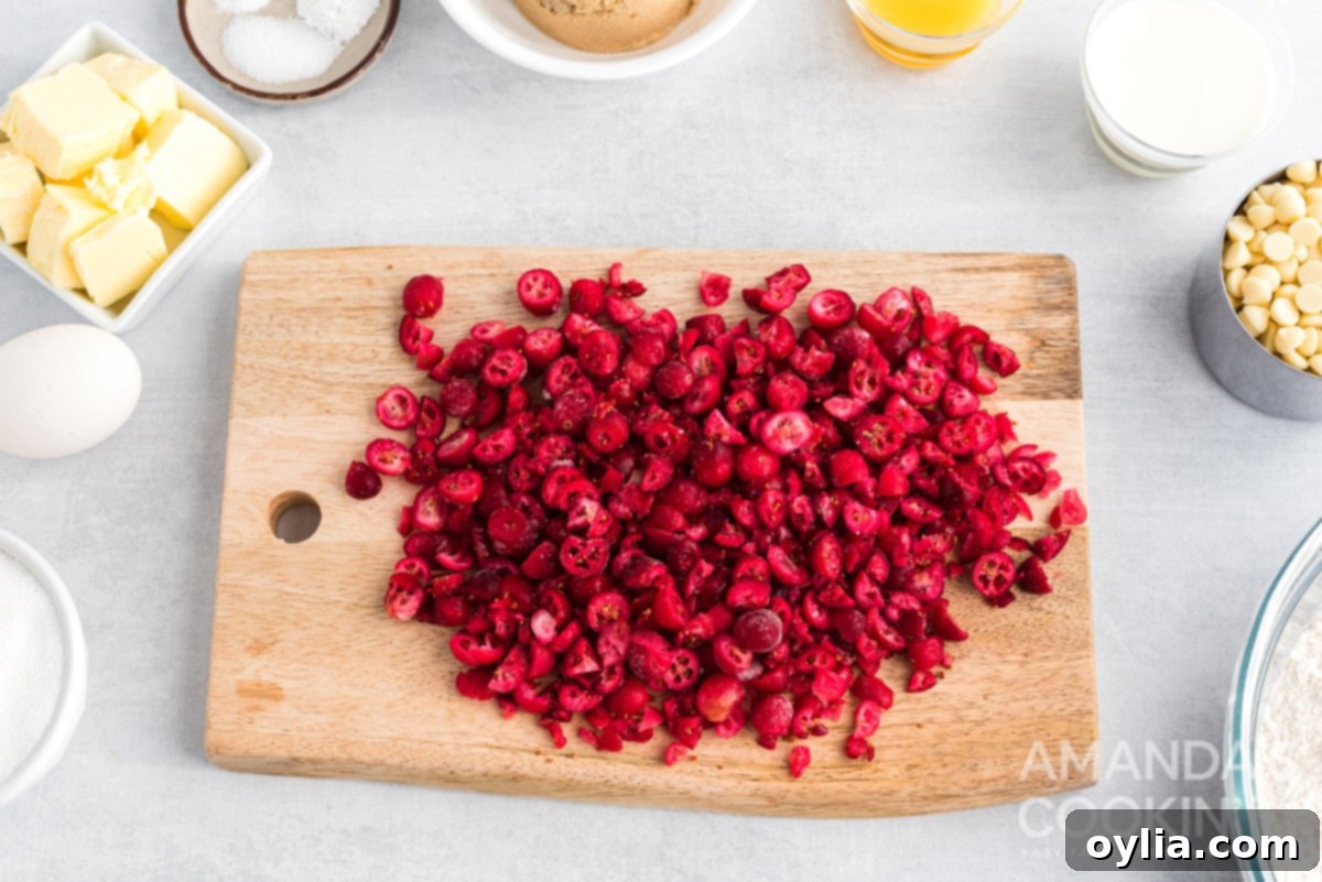 Coarsely chopped frozen cranberries on a cutting board, ready for cookie dough