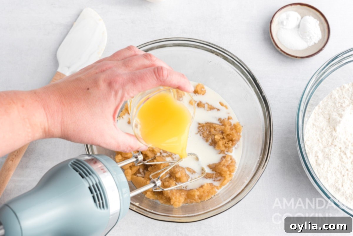 Pouring orange juice into the cookie dough mixture
