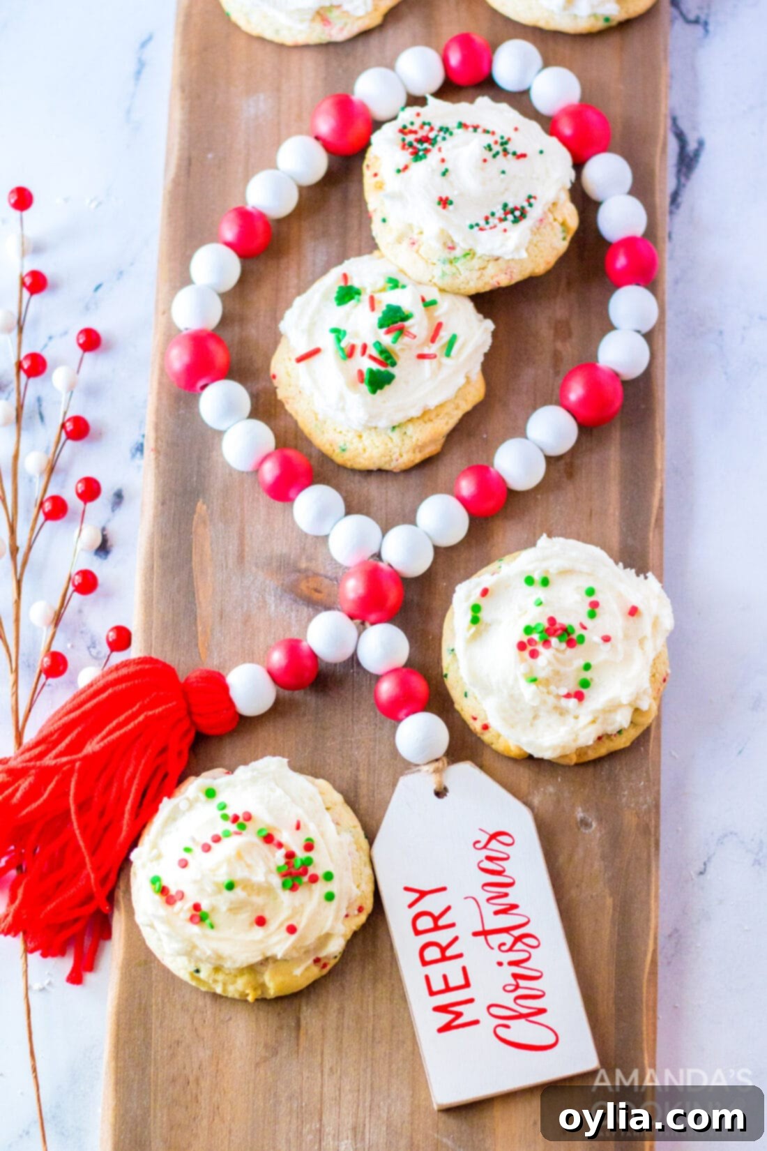 Frosted cake mix cookies with festive sprinkles arranged on a wooden cutting board