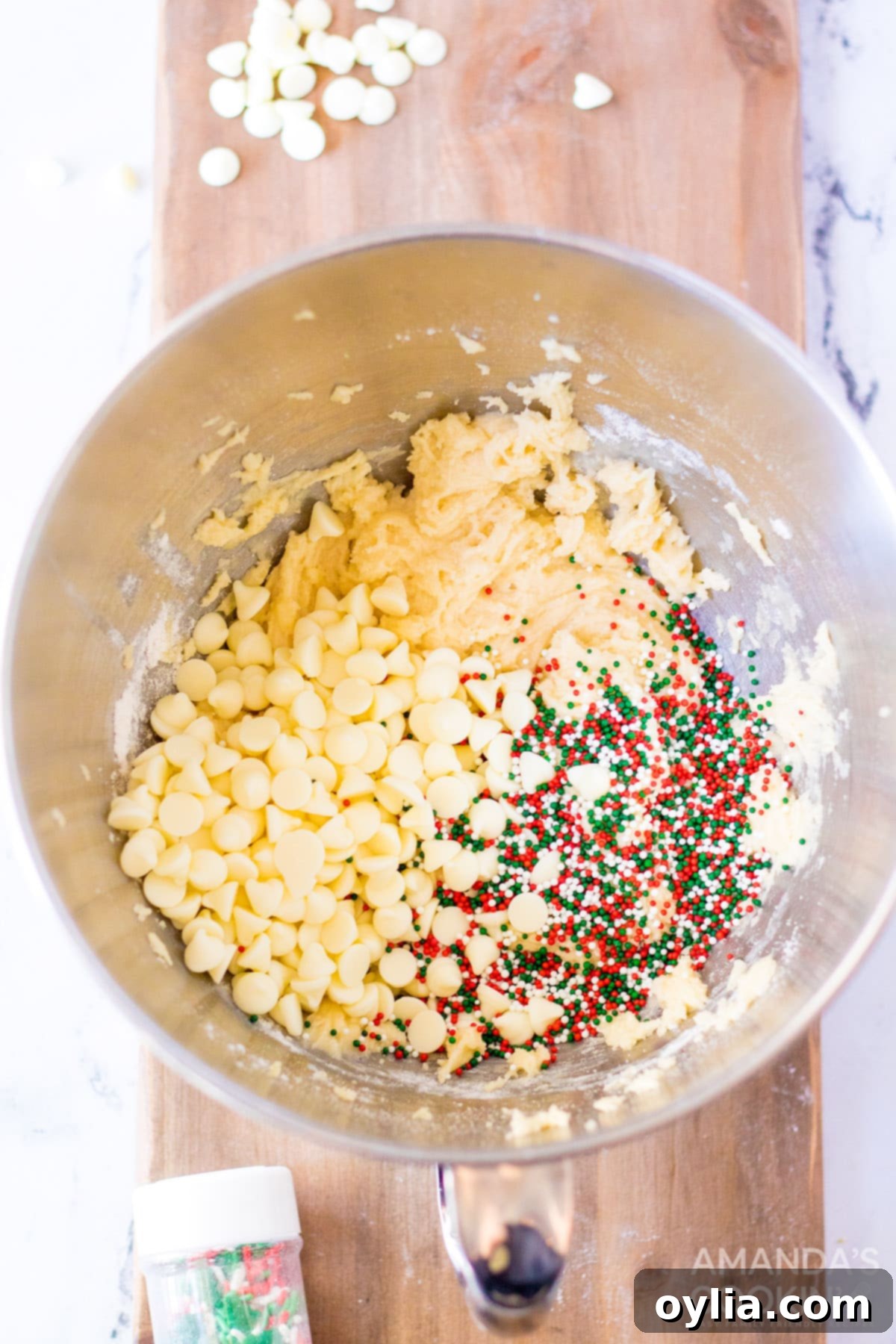 Cake mix cookie ingredients in a bowl, being stirred with a wooden spoon to form the dough