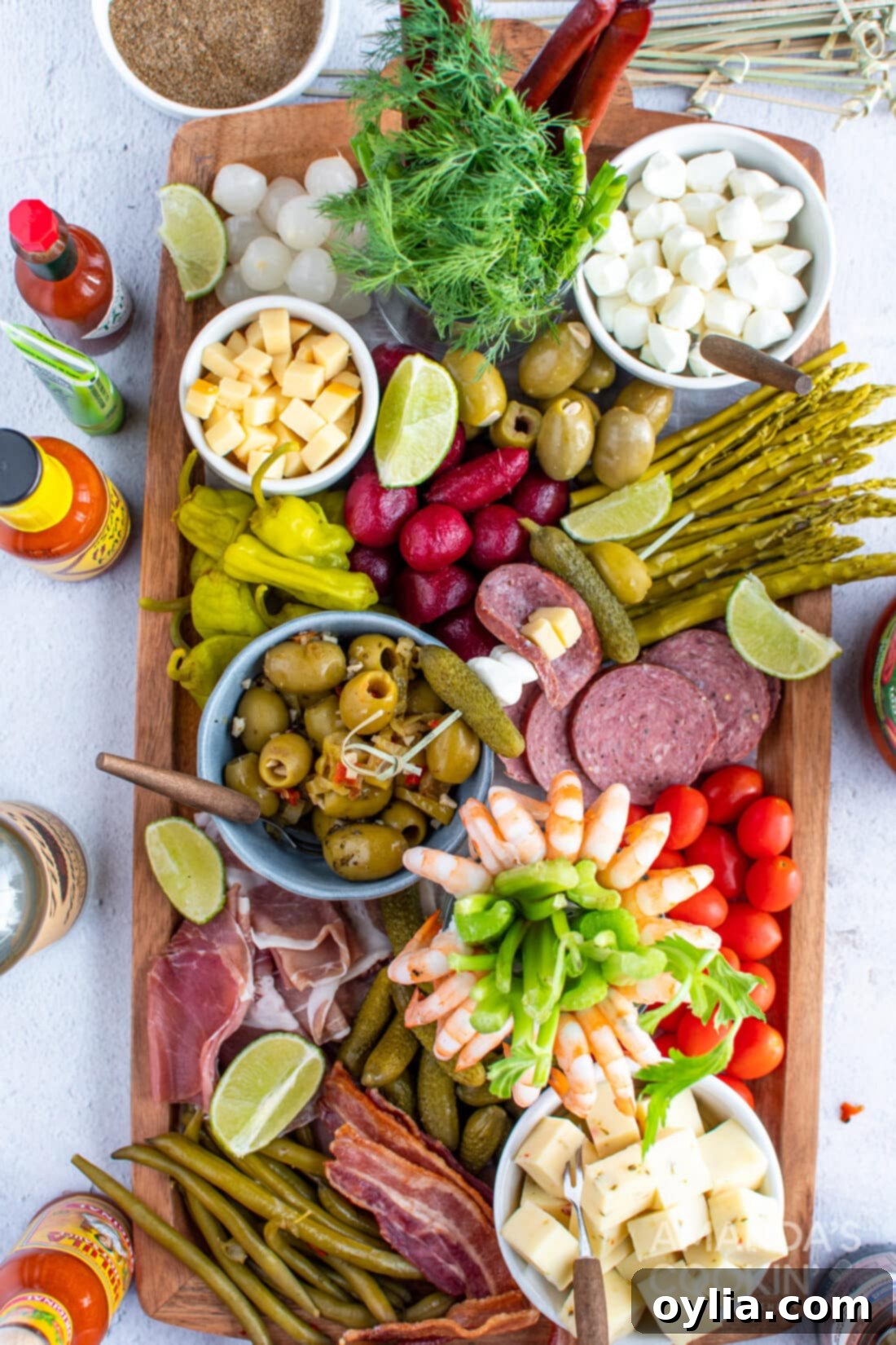 Bloody Mary Charcuterie Board with various garnishes like celery, olives, cheese, and bacon