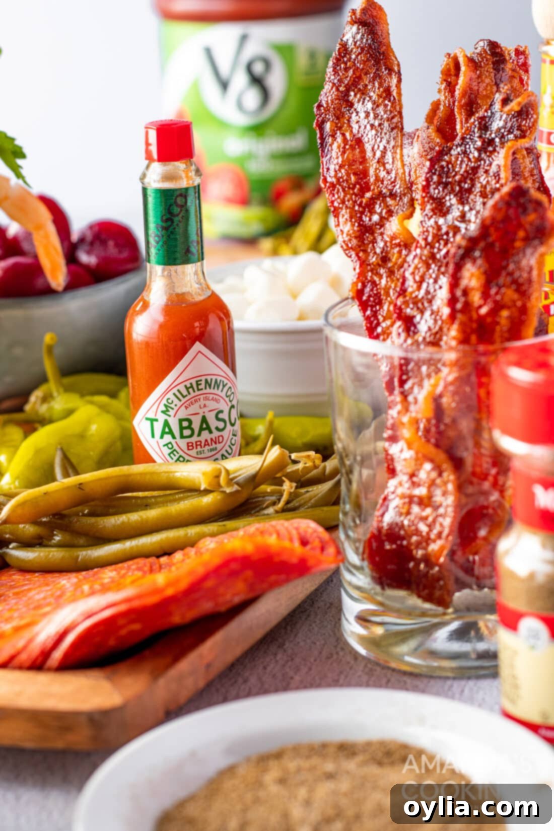 Assortment of Bloody Mary toppings including hot sauce, pickles, and olives