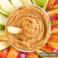 bowl of peanut butter apple dip surrounded by apple slices, ready to serve
