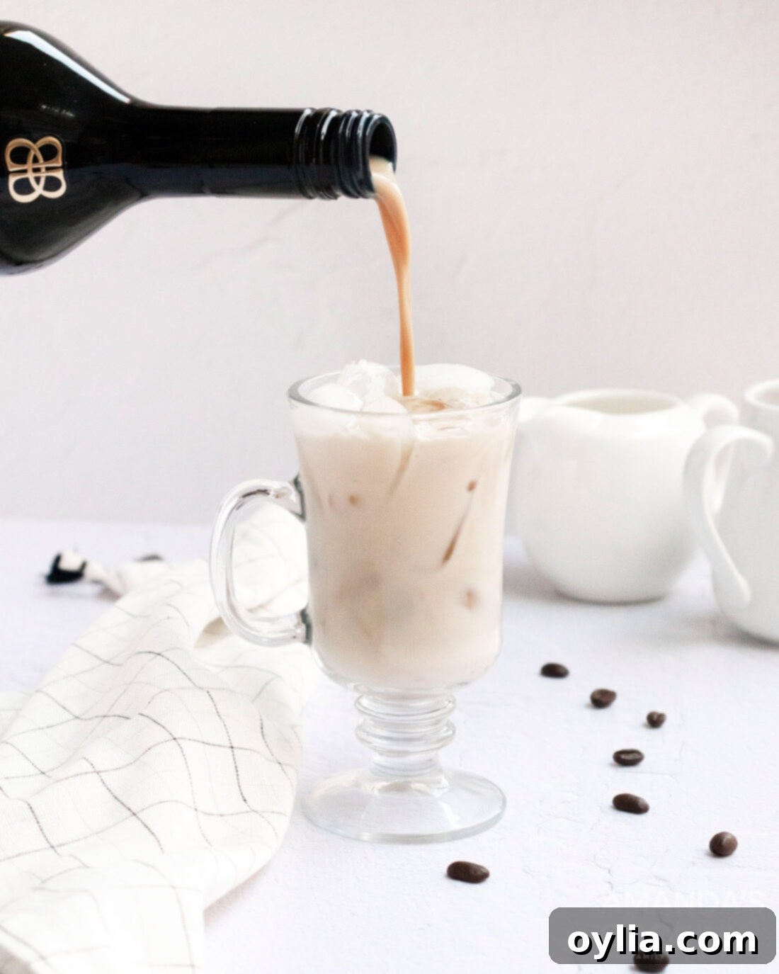 pouring baileys into a white russian