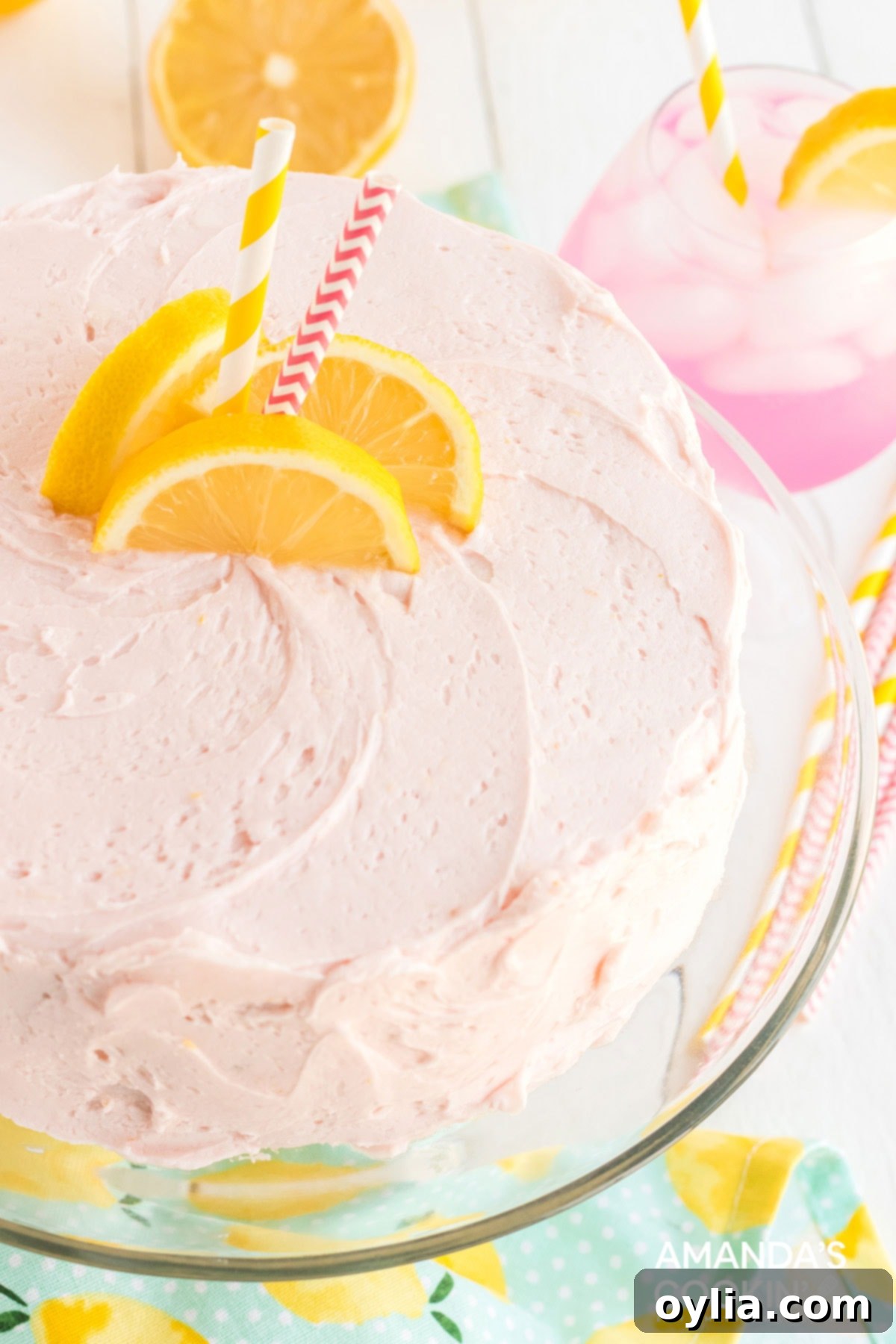 This pink lemonade cake is perfect for summer and will be a huge hit with lemonade fans. Make this beautiful cake from scratch for your next party! pink lemonade cake on a platter