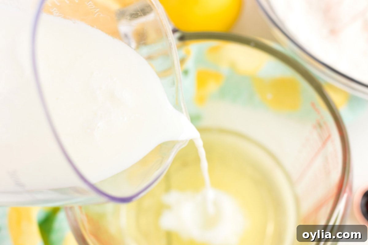 Sparkling Pink Lemonade Cake 5 adding buttermilk to a bowl
