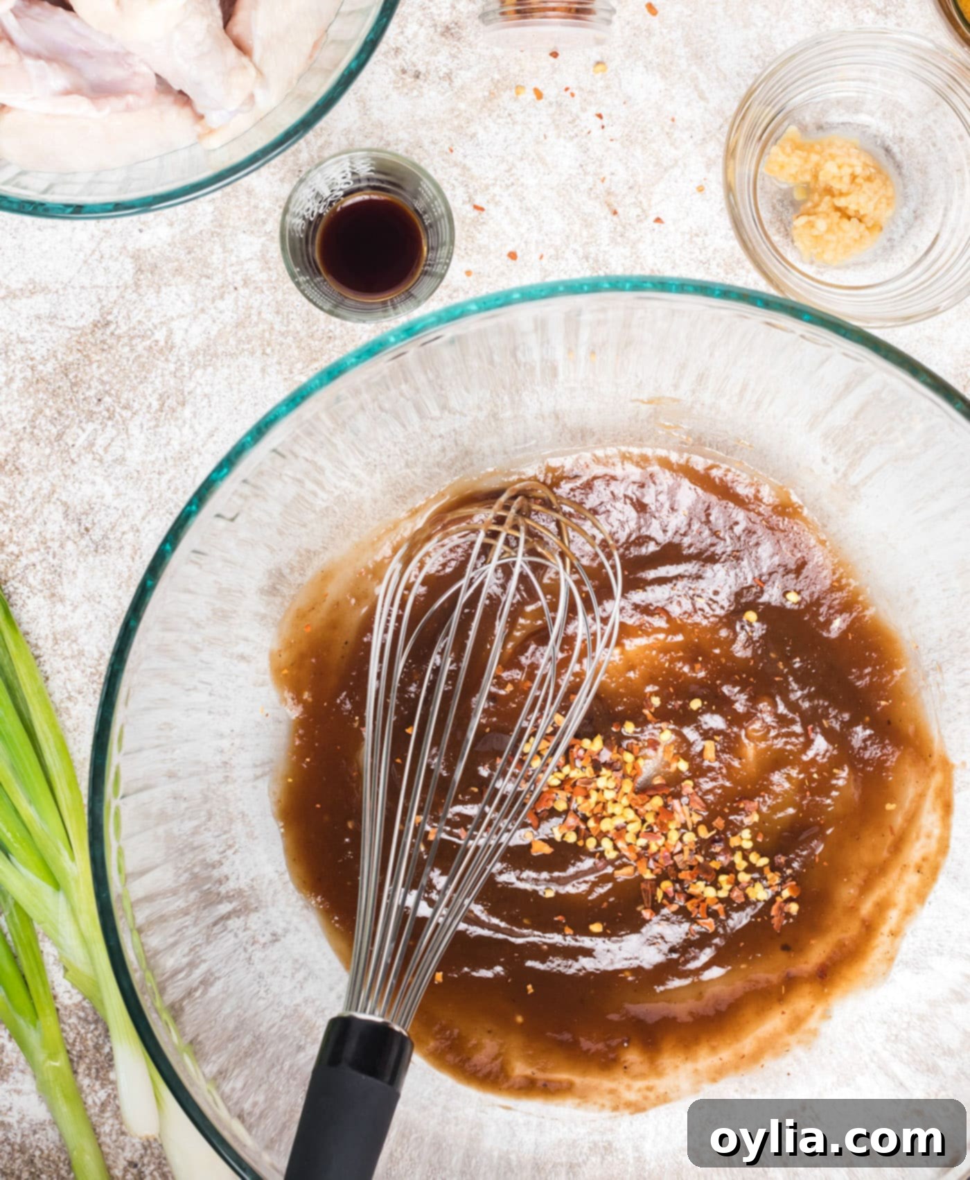 All the wet and dry marinade ingredients being whisked together in a large mixing bowl.